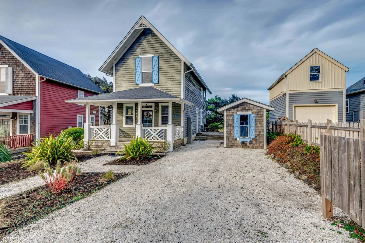 A broad view of the main house, a small shed, and a beautifully landscaped garden. The yard is inviting, with green spaces ideal for family gatherings, outdoor relaxation, and playful moments.